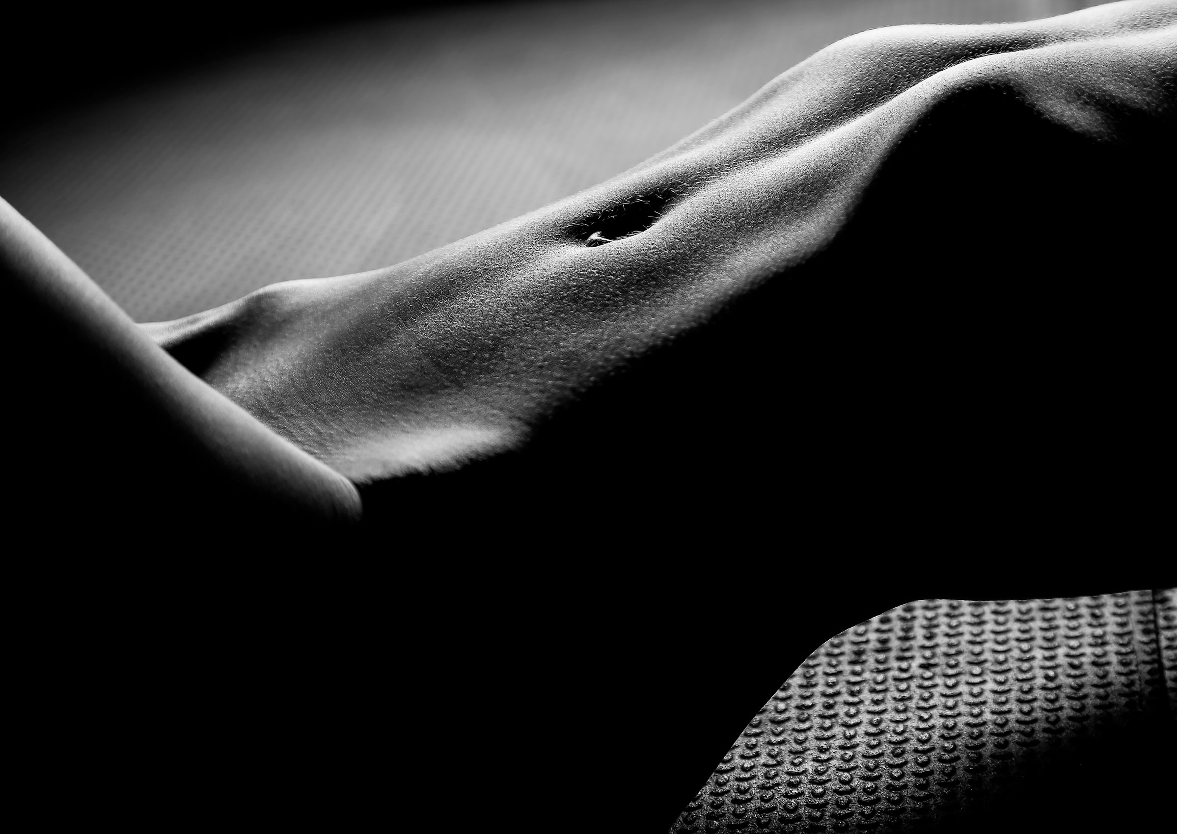Black and white photography of the stomach muscles of a female athlete
